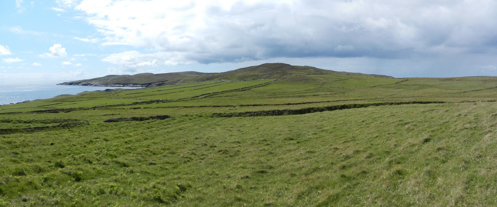 Behind the village is rolling green pastureland.