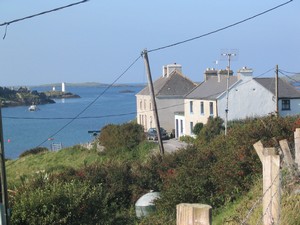Looking across Inishbofin Harbour towards the white navigation marker which marks the harbour entrance and to its left Cromwell's Fort.