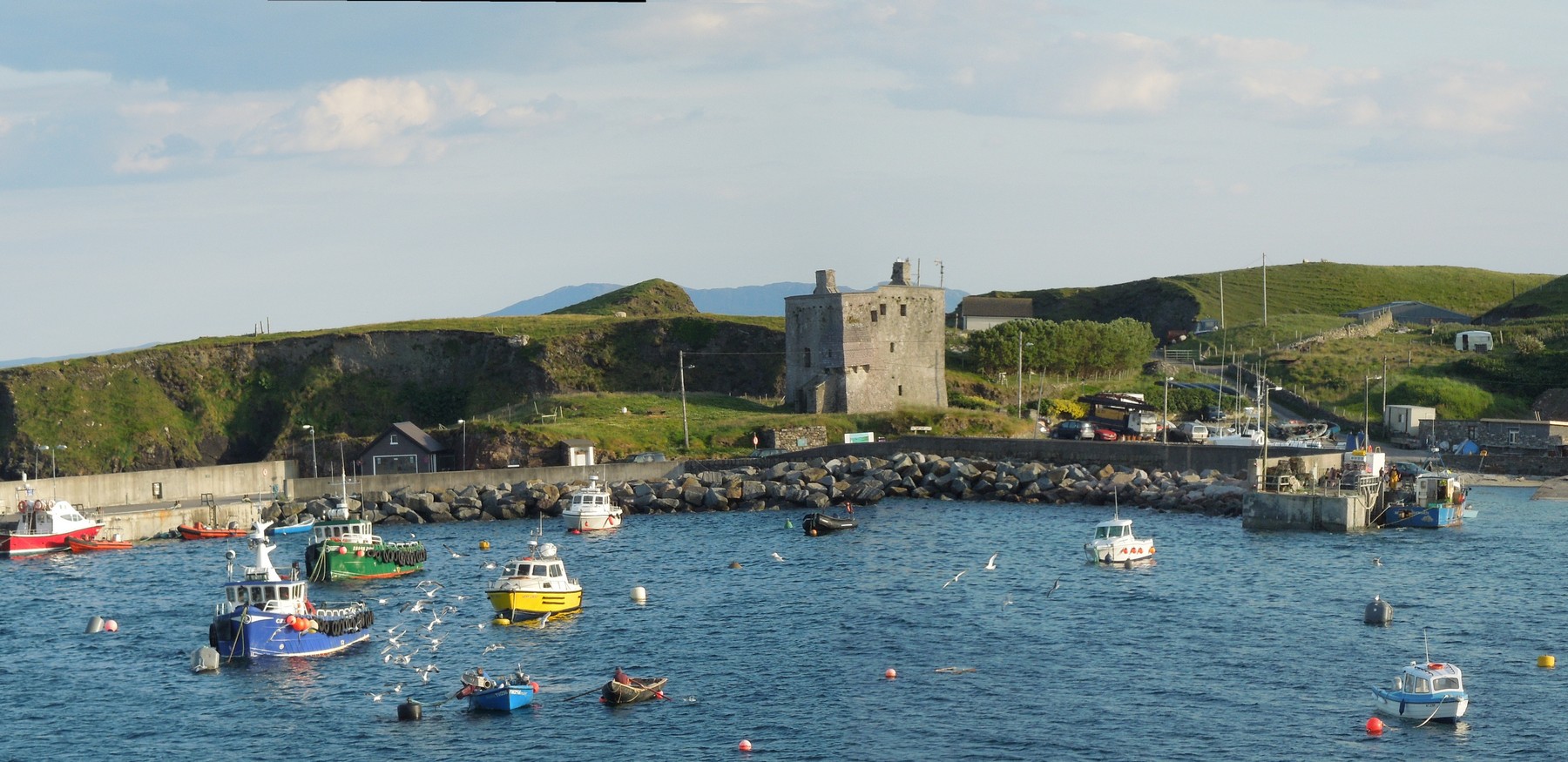 The island's main harbour overlooked by Grinne Uaile's tower house which dates from about 1500.