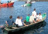 Pilgrims tranship from boats to currachs for the landing on Caher