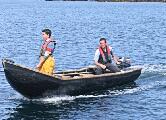 Pilgrims tranship from boats to currachs for the landing on Caher