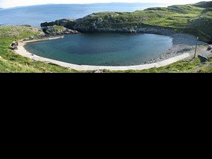 The currach harbour about 1km west of the main harbour. The narrow entrance (with a streelight) is visible as a gap in the rocks to the upper left of the photograph.